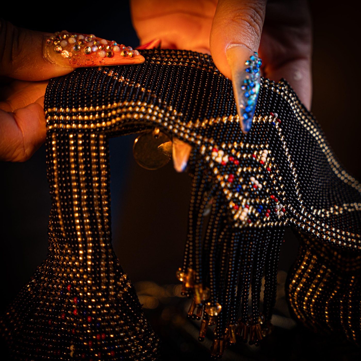 A finished FAIR BLVD piece, hand-beaded in black and gold with fringe
